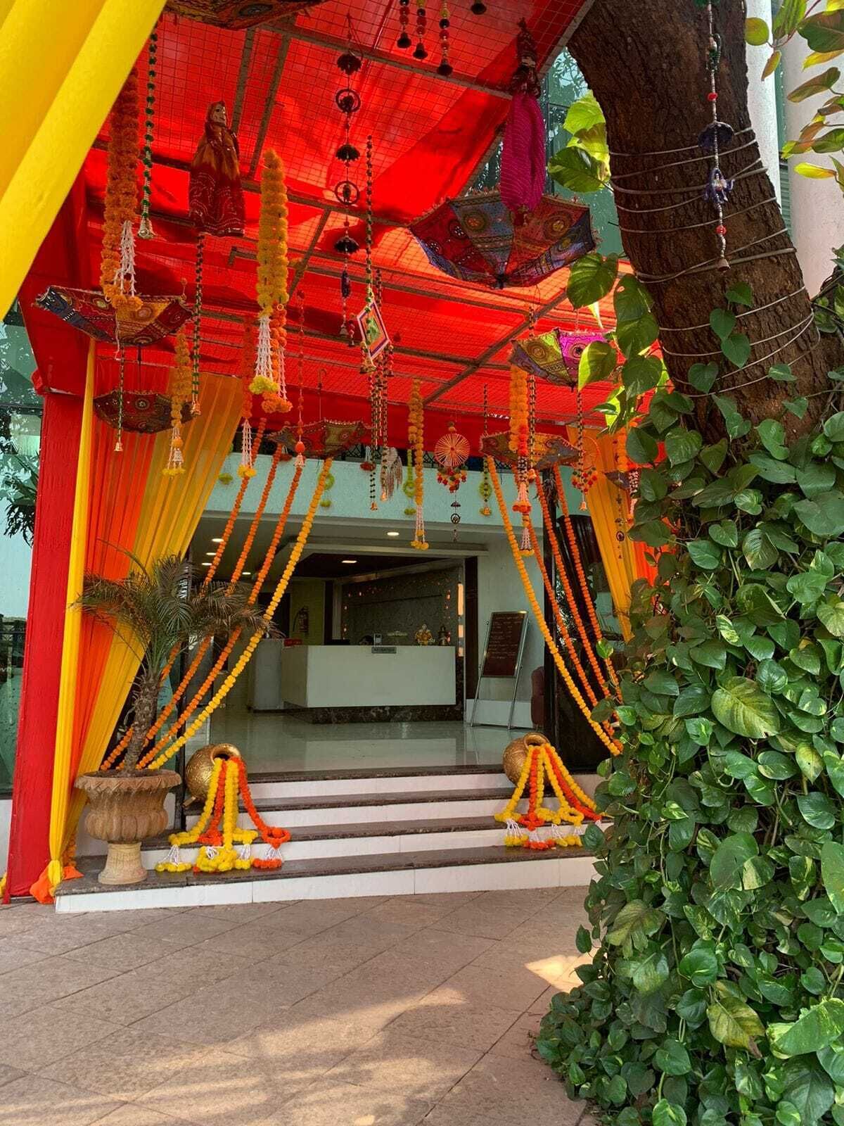 A reception area with a red and yellow draped entrance, a reception desk, and a staircase leading inside.