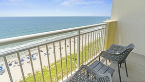 Un balcon avec vue sur la plage et l’océan.