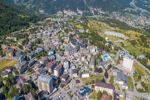 Vue aérienne d’une ville avec des immeubles résidentiels, un rond-point et un grand bâtiment circulaire.
