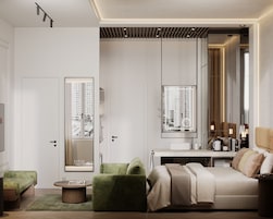 A modern hotel room with a large mirror, a sofa, a bed, and a view of high-rise buildings.