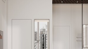 A modern living room with a green sofa, a round coffee table, and a large mirror reflecting a cityscape. - LOVIS Suites Vienna - NEW OPENING (Vienna)
