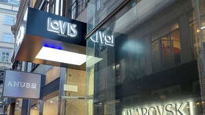 A street view of a building with storefronts including Levi's Suites, Anubhi, and Swarovski. - LOVIS Suites Vienna - NEW OPENING (Vienna)