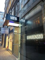 A street view of a building with storefronts including Levi's Suites, Anubhi, and Swarovski.