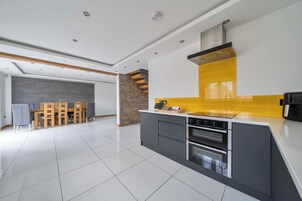 A modern kitchen with a central island, built-in oven, and a yellow backsplash.