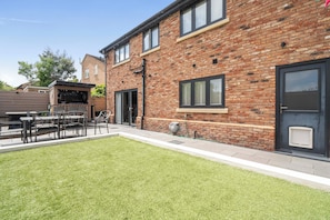 A brick building with a flat roof, a door with a window, and a small window on the side. - Modern, Large 4-bed Property Sleeps 10 in Abergele (Abergele)