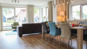 A modern dining area with a sofa, chairs, a table, and a lamp. - Stunning home in Idskenhuizen with sauna (Idskenhuizen)