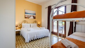 Una habitación de hotel con una cama, una litera, un cuadro, una ventana y un piso con diseño.