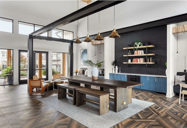 A modern kitchen with a central island, built-in shelves, and a large window overlooking the city.