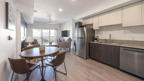 A modern kitchen with a built-in dishwasher, a stainless steel refrigerator, and a granite countertop. - Landing | Chic 2BD, Gym, Pool (Phoenix)