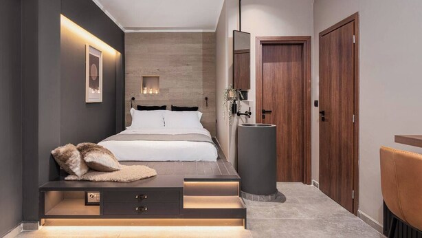 Un dormitorio moderno con una cama grande, mesitas de noche, un espejo y un armario.