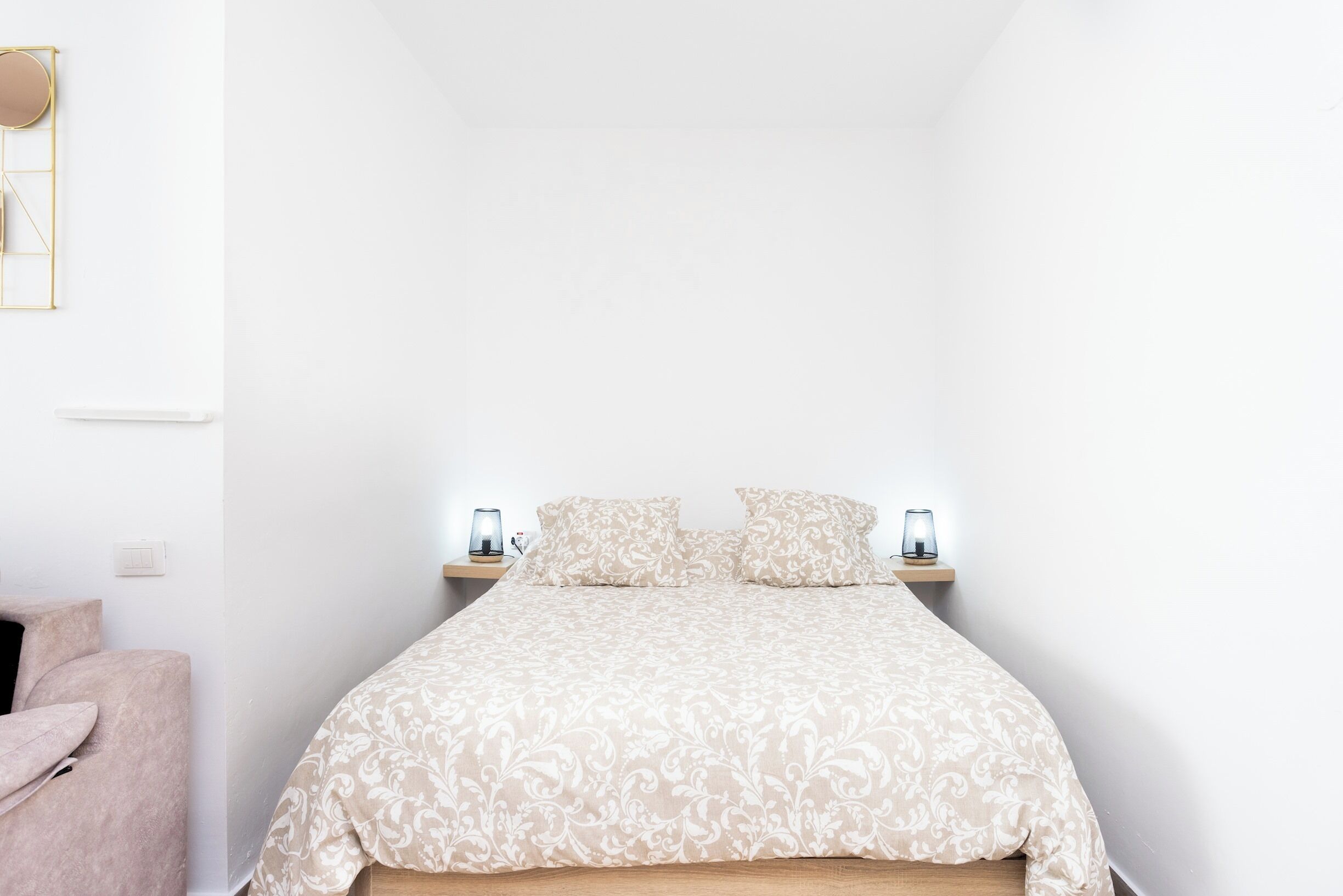 A bedroom with a bed, bedside tables, and a nightstand.