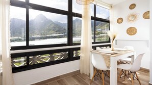 A modern room with a large window, a dining table with chairs, and decorative wall art.