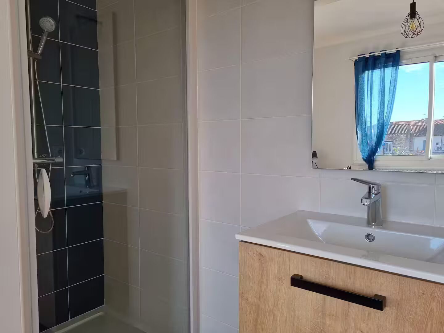 Une salle de bain avec une douche, un lavabo et un miroir.