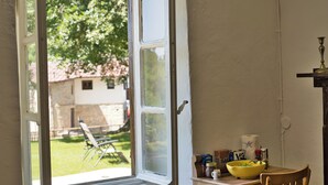 Una habitación con ventana, una mesa con un tazón amarillo y una silla.