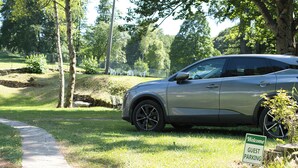 Un coche estacionado en un césped, con un letrero que dice 'Welcome Guest Parking'.