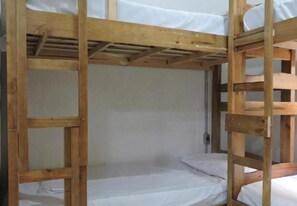 Un lit superposé avec une structure en bois et du linge de lit blanc.