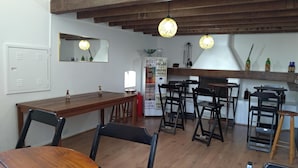 A restaurant with wooden tables and chairs, a mirror on the wall, and hanging lights. - Olah Hostel Paulista (São Paulo)