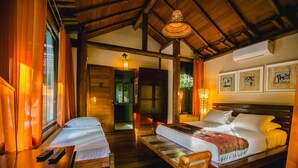 A room with two beds, wooden flooring, a ceiling fan, and a window with curtains. - Legian Villa Hotel (Porto Seguro)