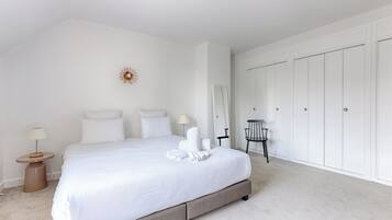 Una camera da letto con un letto grande, un comodino, una sedia e un armadio.