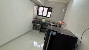 Una cocina pequeña y limpia con refrigerador, pileta y ventana.
