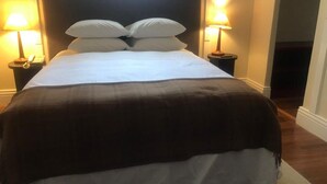 A neatly made bed with a dark brown blanket, two bedside lamps, and a telephone on a nightstand. - Hotel Plaza Central (Arequipa)