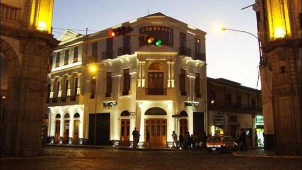 A multi-story building with a central entrance, large windows, and a sign above the door. - Hotel Plaza Central (Arequipa)