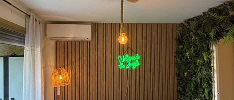 Un soggiorno moderno con un divano verde, un tavolino in legno e una lampada a sospensione.