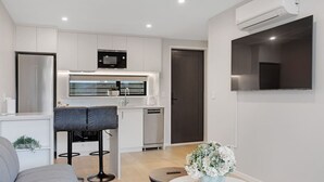 Un appartement moderne comprenant une cuisine, un coin repas et un salon.