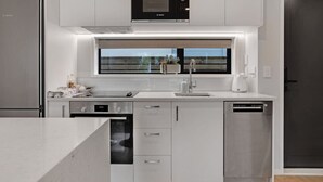 Une cuisine moderne équipée d’un four à micro-ondes, d’un lave-vaisselle et d’un four de la marque Bosch.