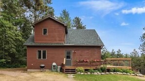 A wooden cabin with a sloped roof, a front porch, and a small deck. - Cabin 9 in Heath's Resort (Pine River)