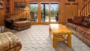 A wooden interior with a sofa, armchair, and a table. - Cabin 15 at Heath's Resort (Pine River)