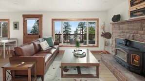 A cozy living room with a leather sofa, a coffee table, and a fireplace.