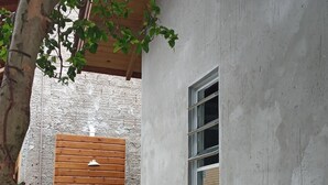 A concrete building with a wooden door and a small window.