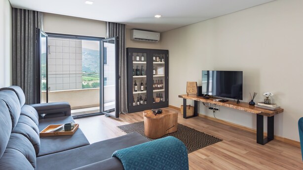 A modern living room with a sofa, a coffee table, a TV, and a bookshelf.