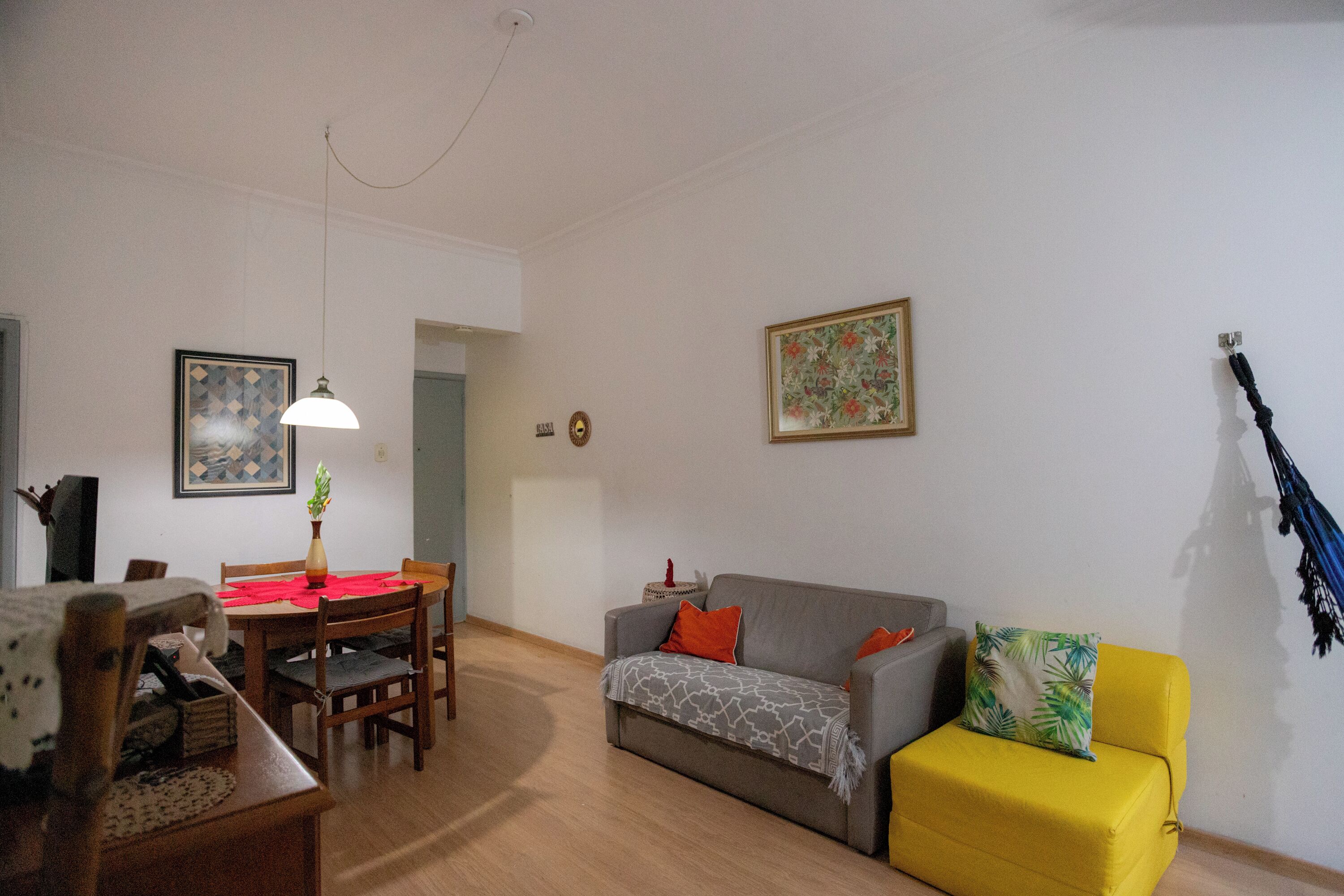 A living room with a dining table, a sofa, and a TV.