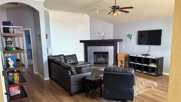 Una sala de estar con chimenea, sofá, una mesa de centro y televisor.