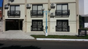 A two-story building with balconies, air conditioning units, and a gated entrance. - Apart Avenida (Concordia)