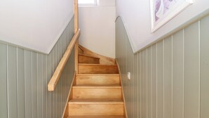 A wooden staircase with a handrail, flanked by vertical paneling on both sides. - Ashlea (Lauder)