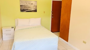 Un dormitorio con cama, mesita de noche y un cuadro colgado en la pared.