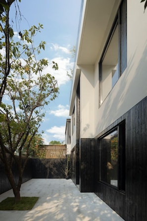 A modern building with large windows and a tree in the foreground.