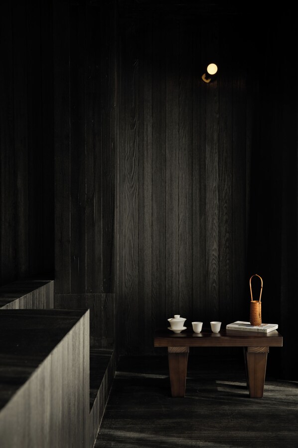 A dark wooden interior with a table set for tea, including cups, a teapot, and a sugar bowl. - PlayHome-Seeing the Soul's Retreat (Hangzhou)