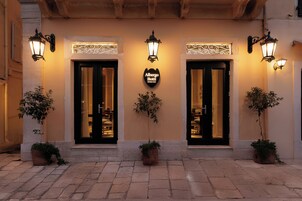Ingresso di un hotel con due porte, ognuna con un cartello sopra e luci decorative a parete.