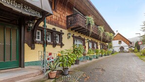 Un bâtiment traditionnel en bois, sur lequel on peut lire l’inscription « Gasthof Zwien ».