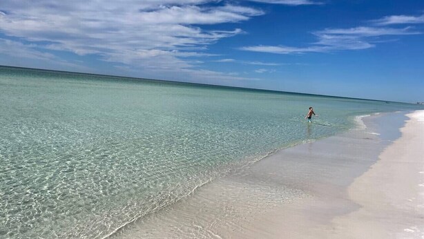 A beach with clear turquoise water and a person walking along the shore. - Coastal Fave- Lrg Private Pool + 2 Min Beach Walk (Santa Rosa Beach)