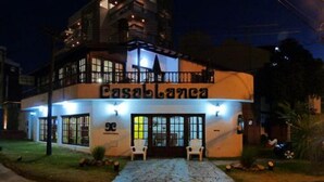 A two-story building with a sign reading "Casablanca". There are two white chairs outside the entrance. - Casablanca (Villa Gesell)