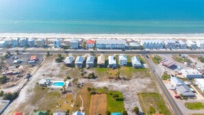 An aerial view of a coastal residential area with houses, a beach, and a road. - Gamer Beach Getaway (Port St. Joe)