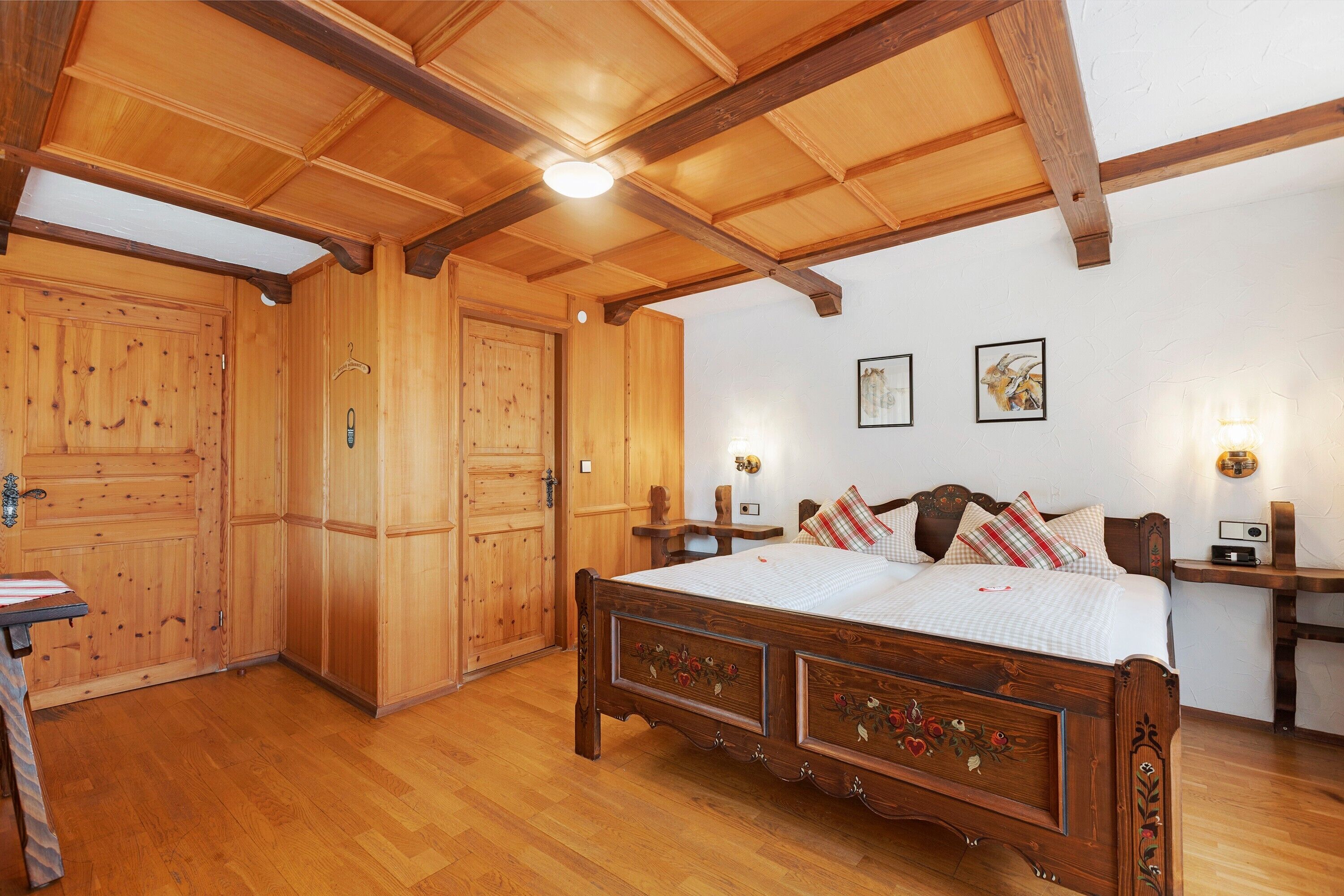 Ein Schlafzimmer aus Holz mit Bett, Kleiderschrank und Nachttischen.