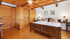 A wooden bedroom with a bed, wardrobe, and bedside tables. - Large Double Room with Shared Garden, Balcony and Wi-Fi (Schramberg)