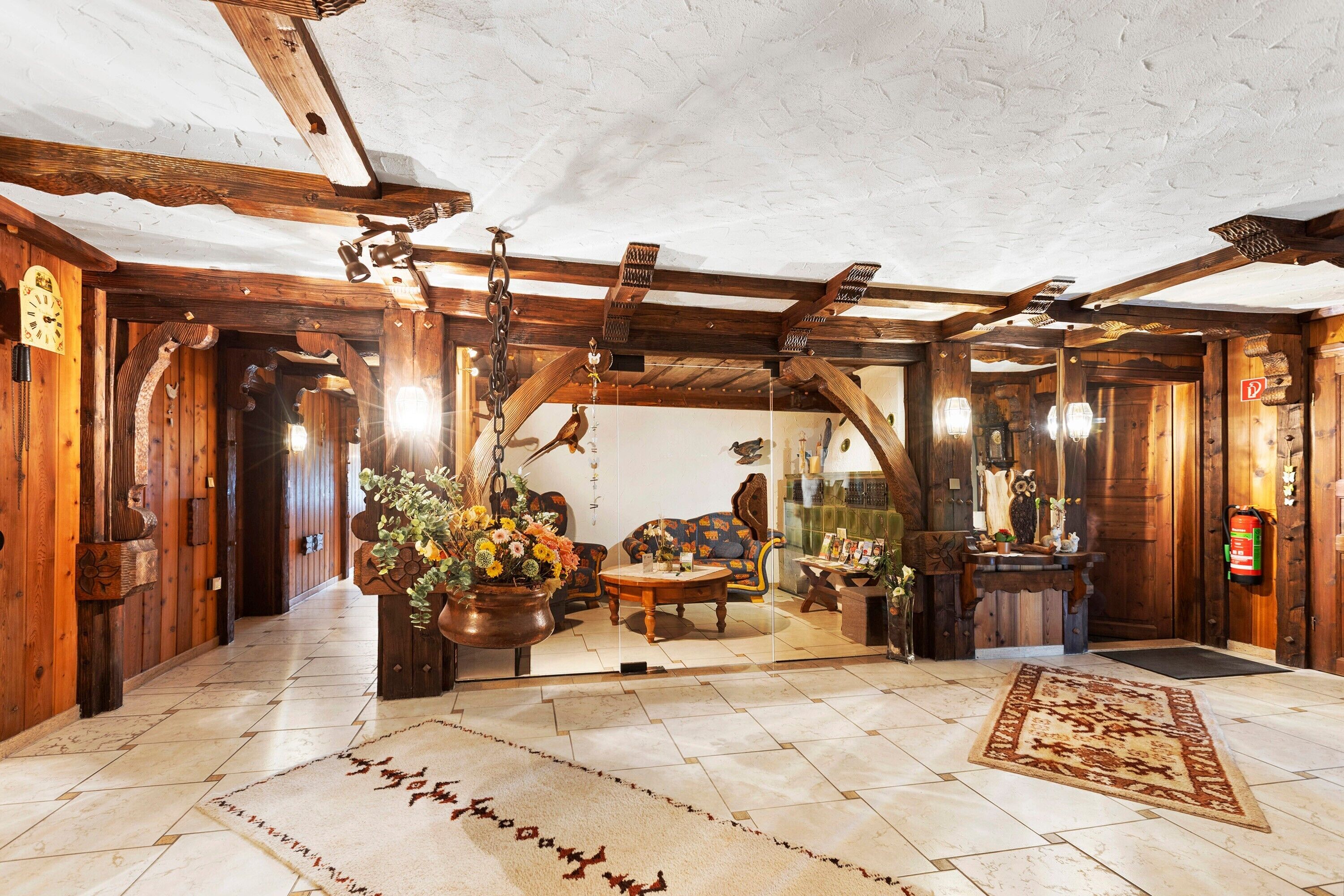 Un intérieur rustique avec des poutres en bois, une cheminée, un canapé et une table basse.