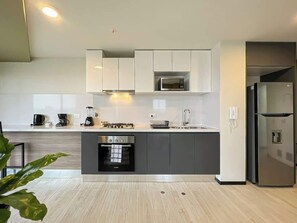 A modern kitchen with a built-in oven, microwave, and refrigerator.